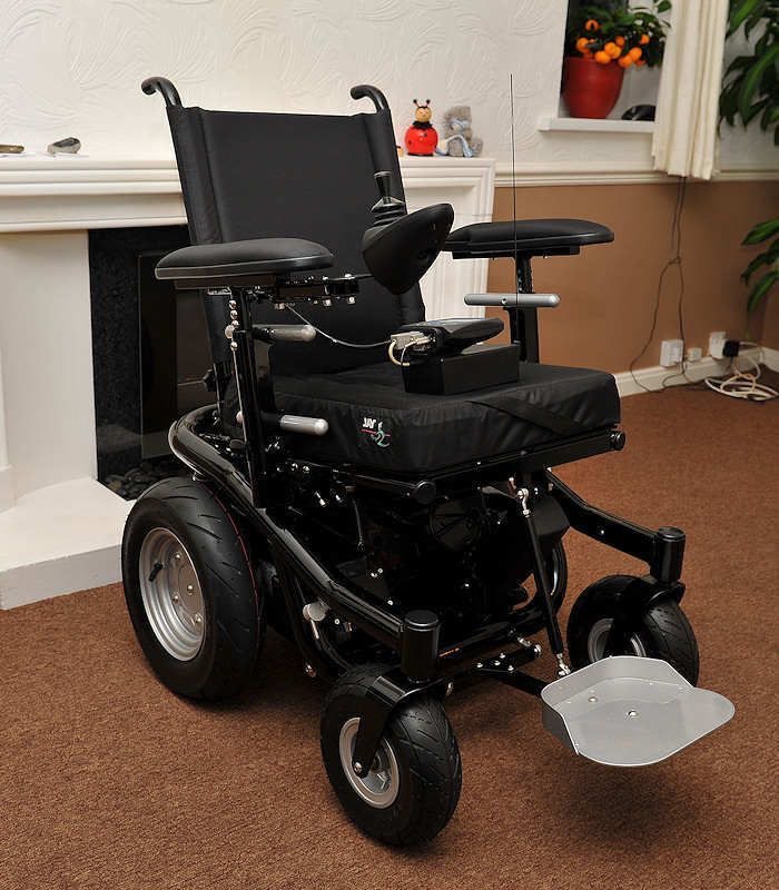 Premium electric wheelchair with red frame, black leather seating, and joystick controller